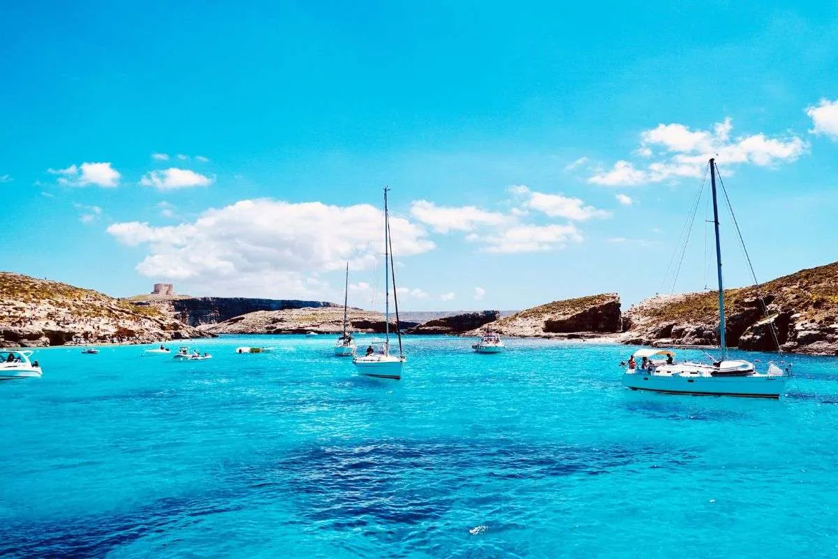 Blue Lagoon auf Comino mit türkisblauem Wasser und vor Anker liegenden Booten – eines der bekanntesten Ausflugsziele Maltas