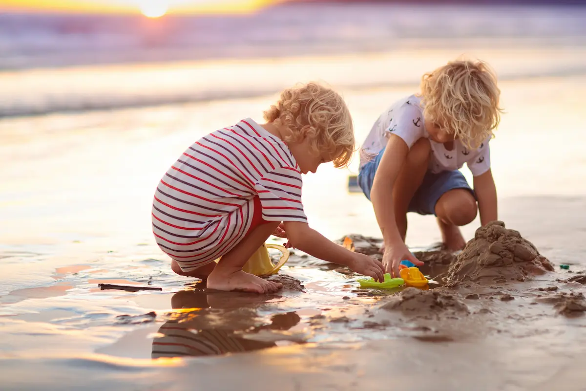 Kinder spielen am flachen Sandstrand auf Malta