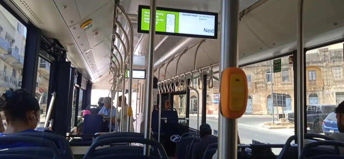 Innenraum eines Busses im öffentlichen Verkehr auf Malta – Fahrgäste und Haltestellenanzeige
